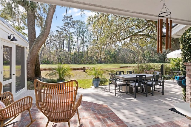 view of patio / terrace with a deck, outdoor dining area, and french doors