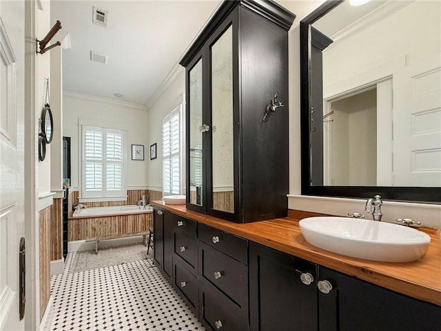 109 Mooring Ln, Saint Marys, GA 31558 - full bathroom featuring ornamental molding, double vanity, a garden tub, and a wainscoted wall