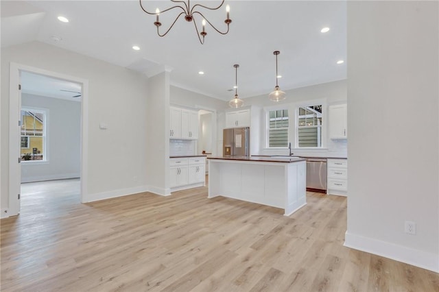 kitchen with a center island, white cabinets, hanging light fixtures, light wood-type flooring, and stainless steel appliances