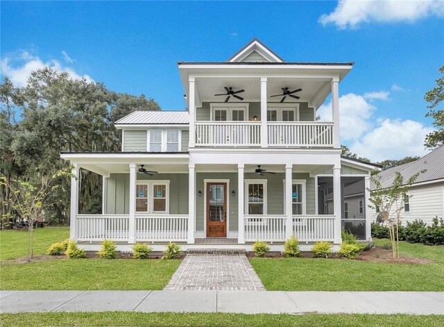 view of front of house with covered porch, a balcony, and a front lawn