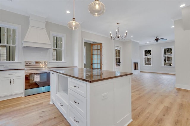 kitchen with premium range hood, white cabinets, a kitchen island, hanging light fixtures, and stainless steel electric range