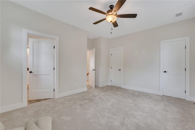 unfurnished bedroom with light colored carpet and ceiling fan