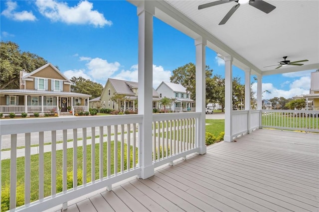 wooden deck with a lawn, ceiling fan, and covered porch