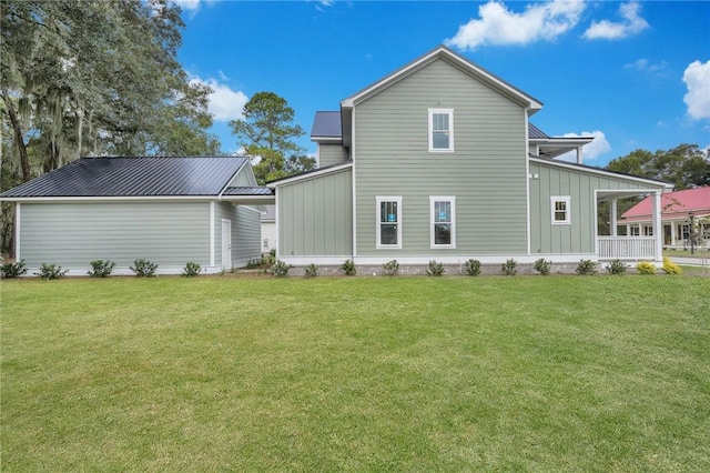 back of house featuring covered porch and a yard