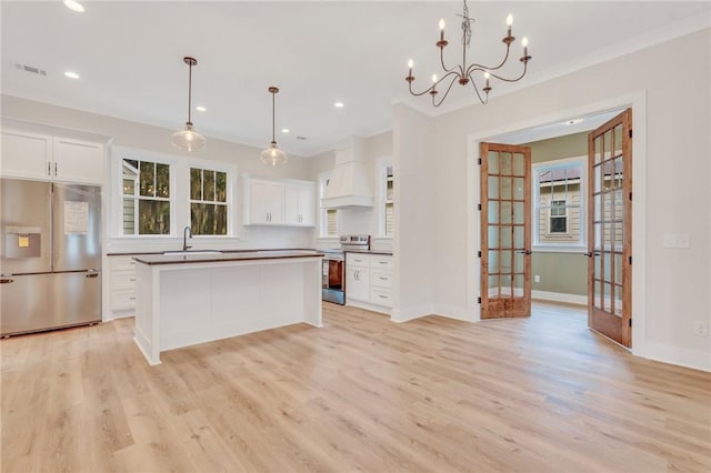 kitchen featuring white cabinets, pendant lighting, light hardwood / wood-style floors, and appliances with stainless steel finishes