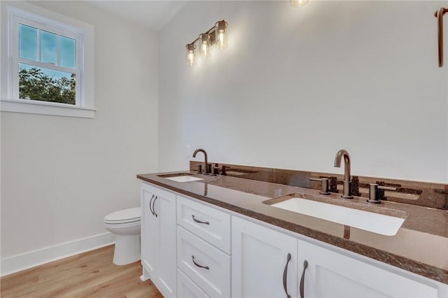 bathroom with toilet, vanity, and hardwood / wood-style flooring