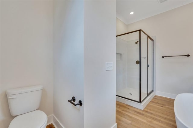 bathroom with wood-type flooring, toilet, and a shower with shower door