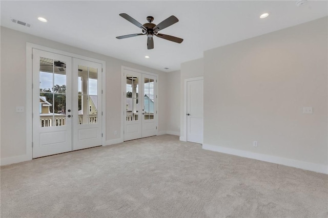 empty room featuring light carpet, french doors, plenty of natural light, and ceiling fan