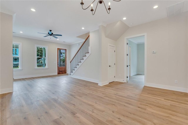 unfurnished living room featuring ceiling fan with notable chandelier and light hardwood / wood-style flooring