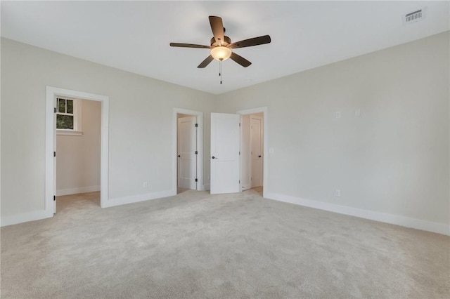 unfurnished bedroom featuring ceiling fan, light colored carpet, a spacious closet, and a closet