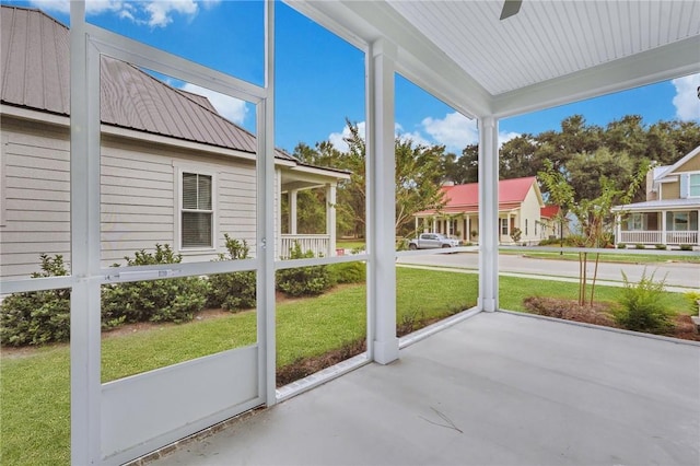 unfurnished sunroom with ceiling fan