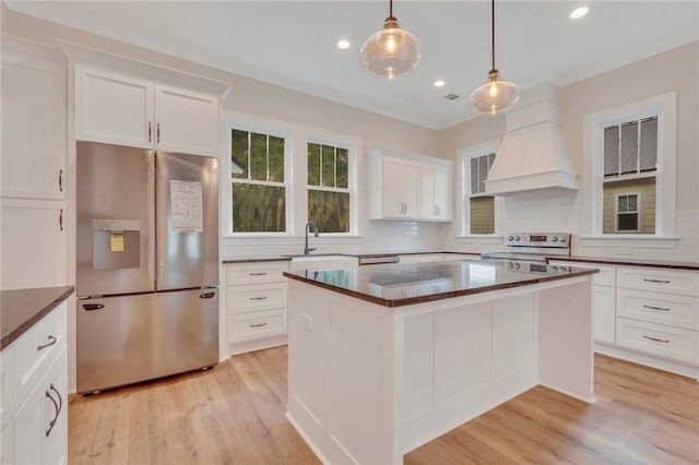 kitchen with stainless steel fridge, light hardwood / wood-style flooring, electric range, and a kitchen island