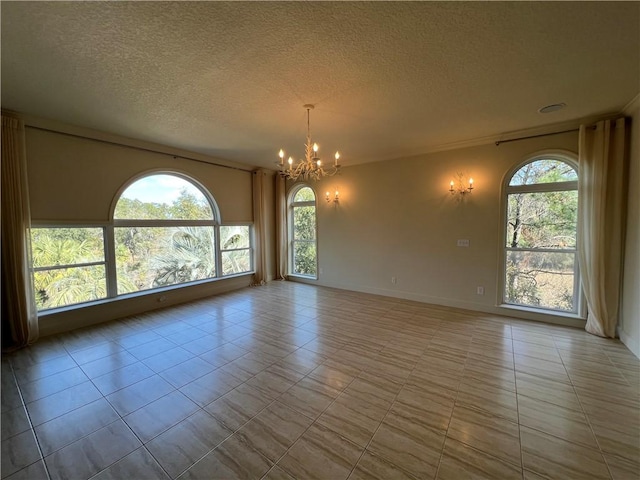 tiled spare room with a chandelier and a textured ceiling