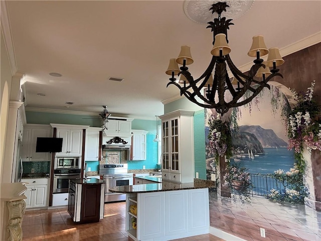 kitchen featuring appliances with stainless steel finishes, white cabinets, backsplash, crown molding, and wall chimney range hood