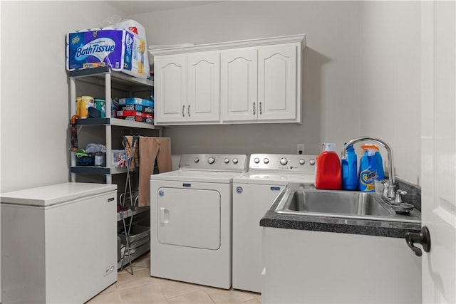 laundry area featuring sink, light tile patterned floors, cabinets, and independent washer and dryer