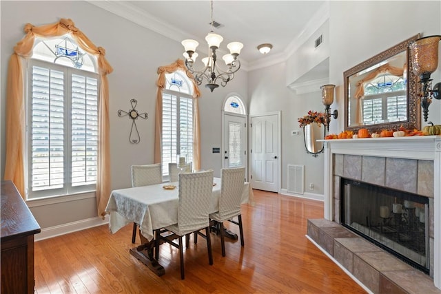 dining room with light hardwood / wood-style flooring, a healthy amount of sunlight, and ornamental molding