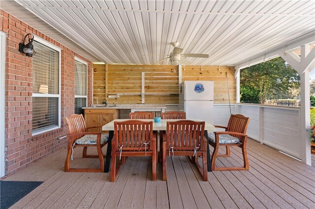 sunroom featuring ceiling fan and sink