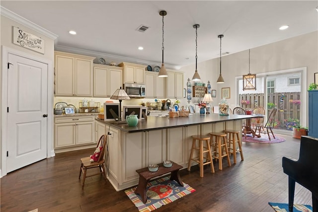 19 Sinclair Way, Saint Simons Island, GA 31522 - kitchen featuring cream cabinetry, a kitchen island, dark hardwood / wood-style flooring, and hanging light fixtures