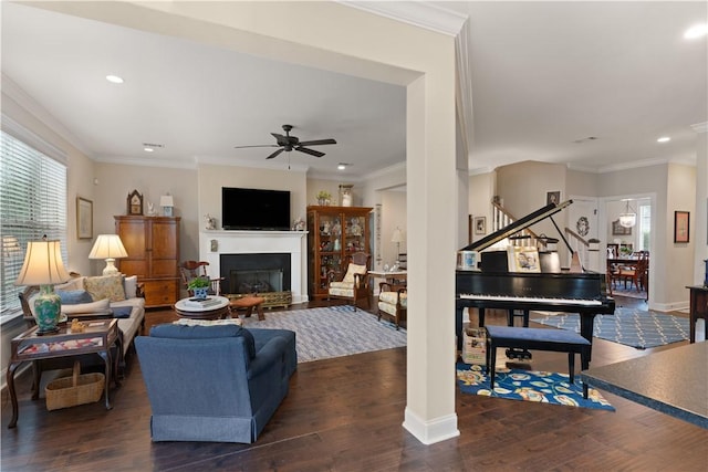 living room with ceiling fan, dark hardwood / wood-style flooring, and ornamental molding