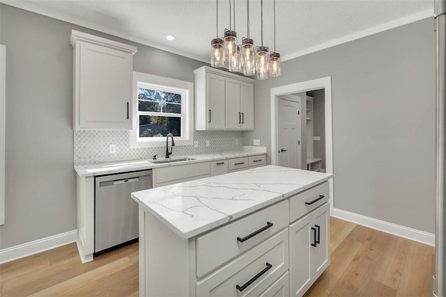 kitchen featuring light wood-type flooring, stainless steel dishwasher, sink, white cabinets, and a center island