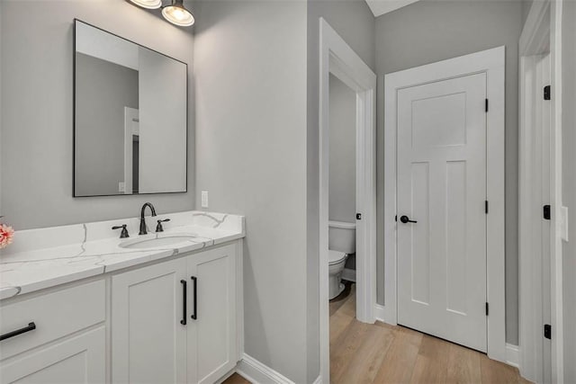 bathroom featuring hardwood / wood-style flooring, vanity, and toilet