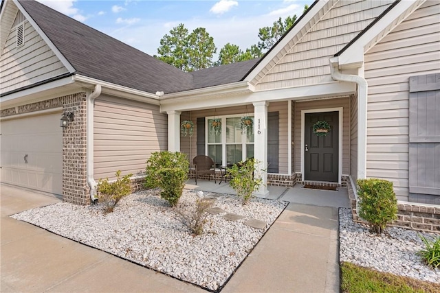 116 Heatherly Way, Brunswick, GA 31523 - property entrance featuring a porch, roof with shingles, brick siding, a garage, and driveway