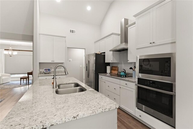 116 Heatherly Way, Brunswick, GA 31523 - kitchen with black appliances, a sink, wall chimney range hood, wood finished floors, and a chandelier