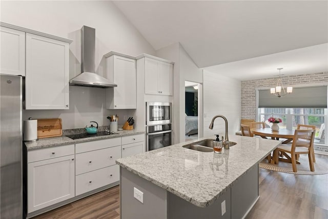 116 Heatherly Way, Brunswick, GA 31523 - kitchen featuring wall chimney exhaust hood, a sink, stainless steel appliances, vaulted ceiling, and wood finished floors