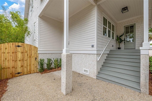 view of side of home featuring a gate and crawl space
