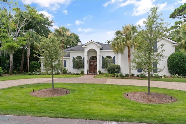 mediterranean / spanish home with a front lawn