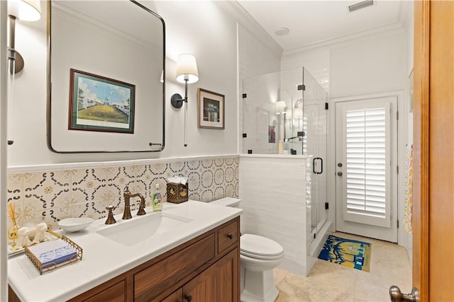 bathroom with tile patterned floors, toilet, vanity, a shower with shower door, and ornamental molding