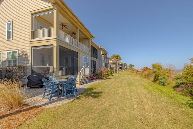 view of yard featuring a patio, a balcony, and ceiling fan