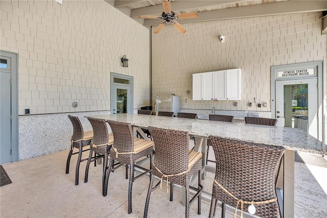 view of patio / terrace featuring ceiling fan and a bar