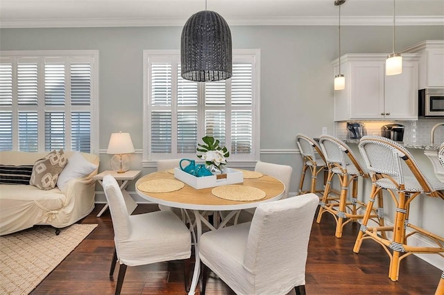 dining area featuring crown molding and dark wood-type flooring