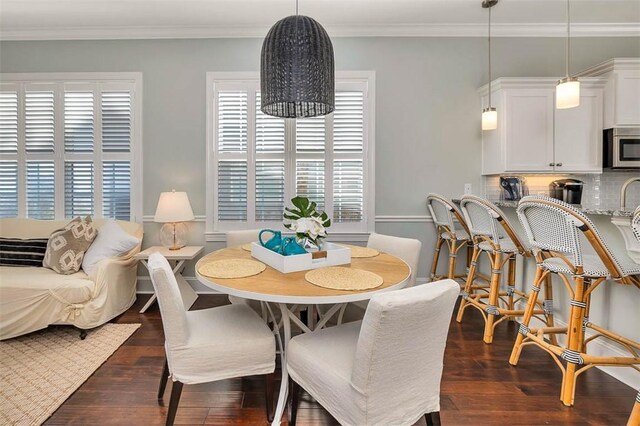 dining area featuring crown molding and dark wood-type flooring