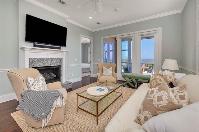 living room with ornamental molding, dark wood-type flooring, and a high end fireplace