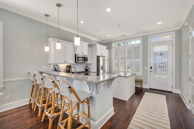 kitchen with kitchen peninsula, appliances with stainless steel finishes, dark wood-type flooring, pendant lighting, and white cabinetry