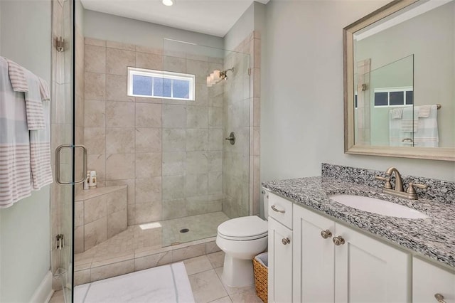 bathroom featuring tile patterned flooring, vanity, a shower with door, and toilet