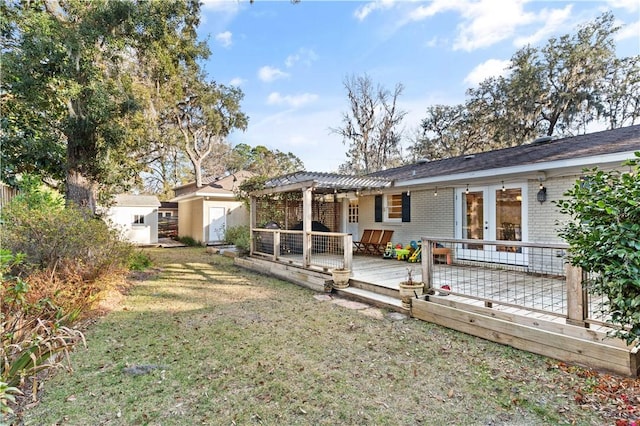 rear view of property featuring a storage shed, a pergola, a deck, and a lawn