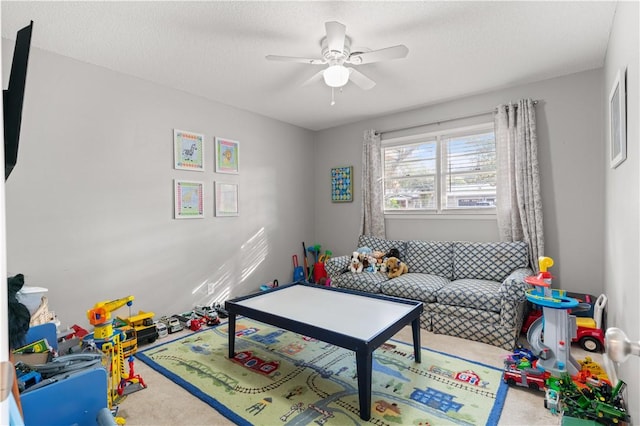 game room with a textured ceiling and ceiling fan