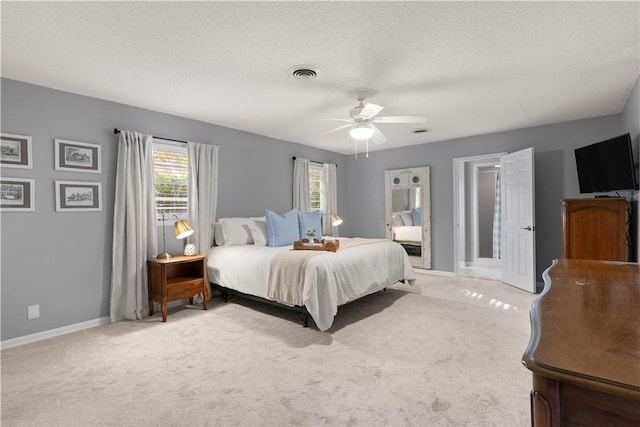 carpeted bedroom with ceiling fan and a textured ceiling