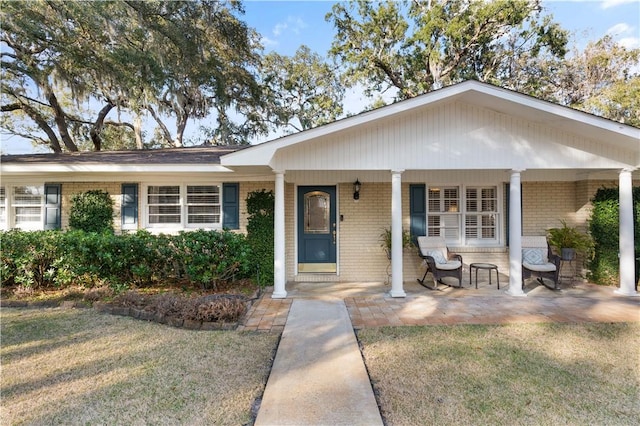 ranch-style home featuring a porch and a front yard