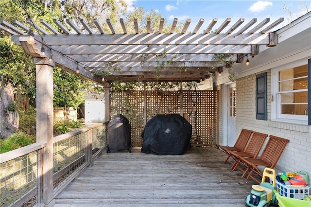 wooden terrace featuring a grill and a pergola