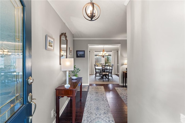 interior space with dark hardwood / wood-style flooring, a notable chandelier, and ornamental molding