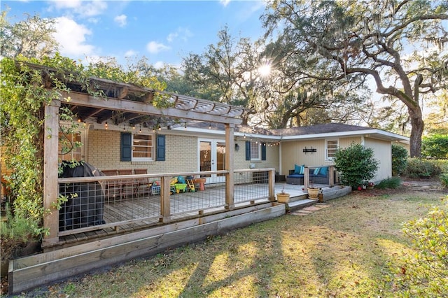 back of property with a wooden deck, an outdoor hangout area, and a yard