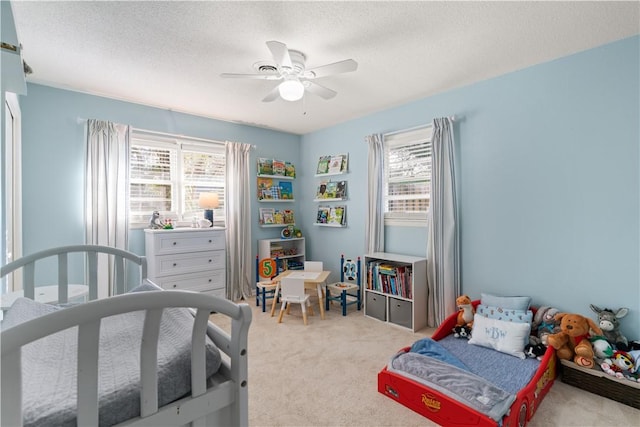 carpeted bedroom with ceiling fan and a textured ceiling