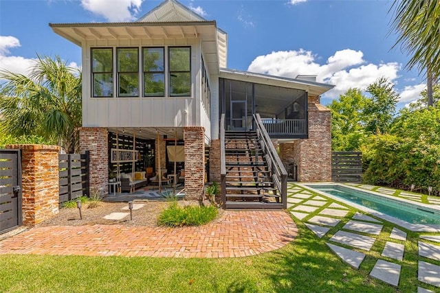 10 Fern Ln, Saint Simons Island, GA 31522 - back of property featuring a sunroom, a patio area, an outdoor pool, and stairs