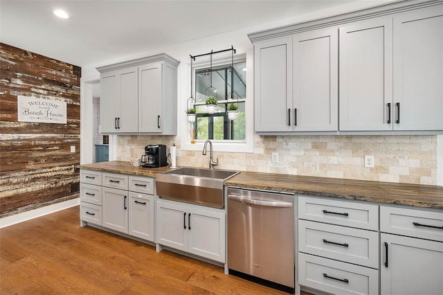 10 Fern Ln, Saint Simons Island, GA 31522 - kitchen with stainless steel dishwasher, tasteful backsplash, wooden walls, light wood-type flooring, and recessed lighting