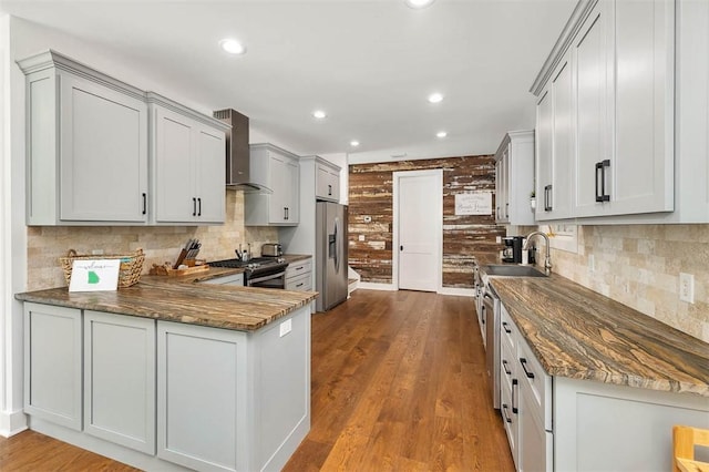 10 Fern Ln, Saint Simons Island, GA 31522 - kitchen featuring stainless steel appliances, wall chimney range hood, dark stone countertops, recessed lighting, and decorative backsplash