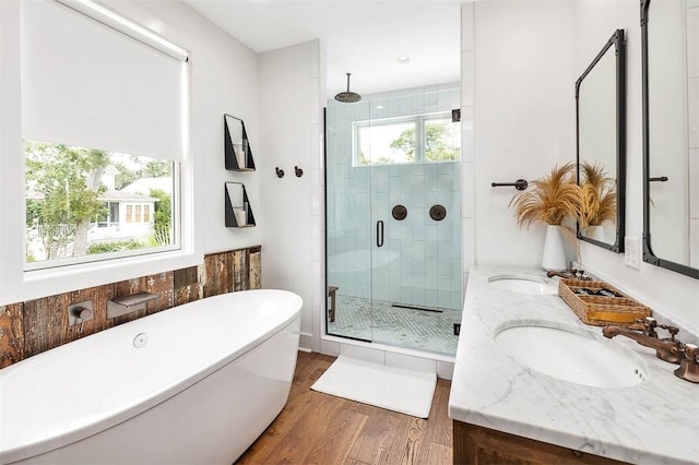 10 Fern Ln, Saint Simons Island, GA 31522 - bathroom featuring a shower stall, wood finished floors, double vanity, and a soaking tub
